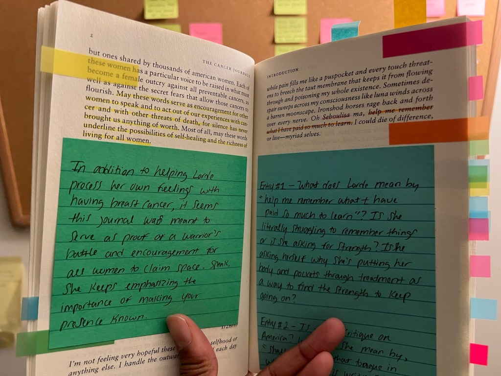 A hand holding an annotated book open 